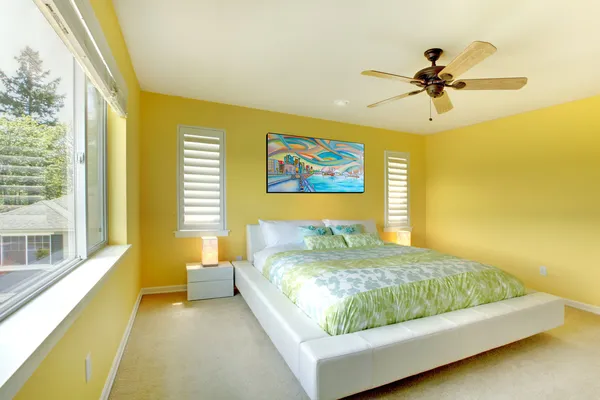 Yellow modern bedroom with white bed.