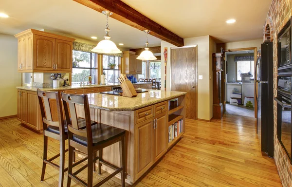 Large wood kitchen with hardwod floor and wood beam.