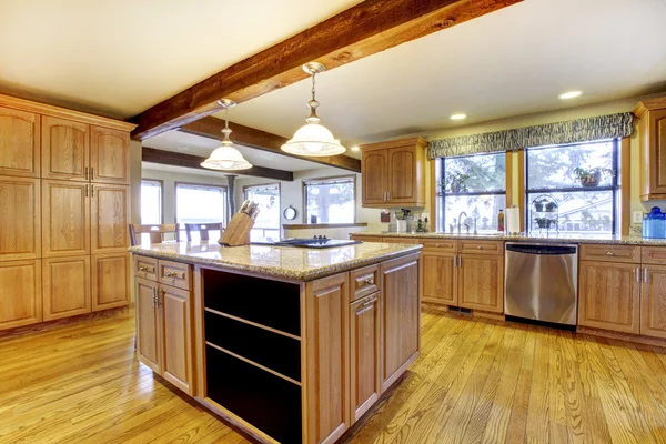 Large wood kitchen with island and wood beam.