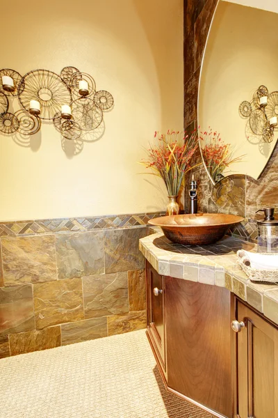 Metal Sink with wood cabinet and stone tiles.