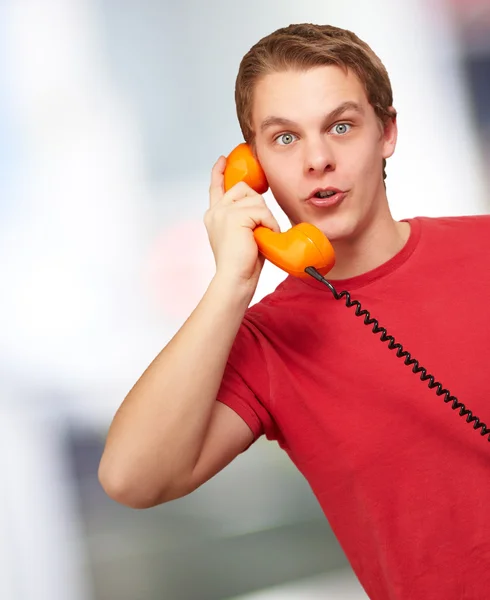 Portrait of a young man talking on vintage phone