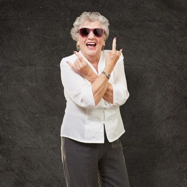 Senior woman wearing sunglasses doing funky action