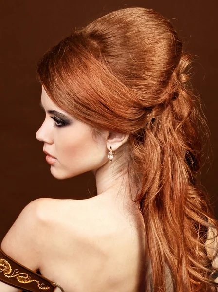 Beautiful woman with red hairstyle luxuriant long hair.