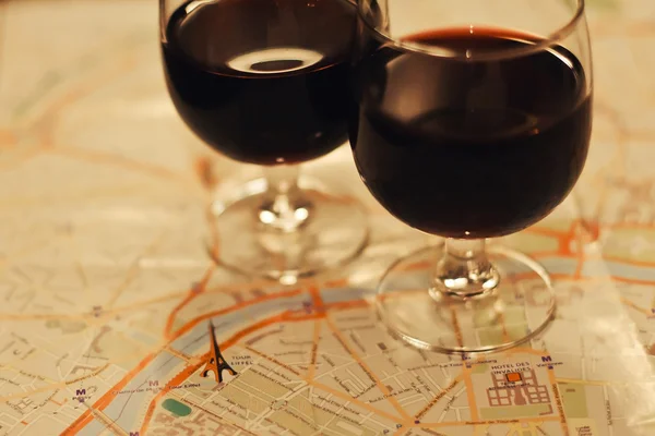Wine in two wineglasses standing on the map of Paris