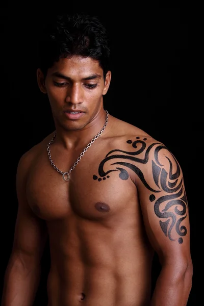 A muscular Indian man with body painting