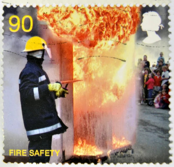 UNITED KINGDOM - CIRCA 2009: a stamp printed in UK shows a firefighter putting out a fire, fire safety, circa 2009