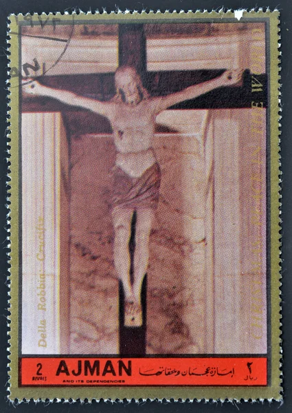 AJMAN - CIRCA 1972: A stamp printed in Ajman, Christmas collection, peace in the world, shows a sculpture of the crucifixion of Christ Della Robbia work , circa 1972