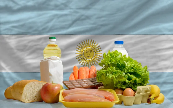 Basic food groceries in front of argentina national flag