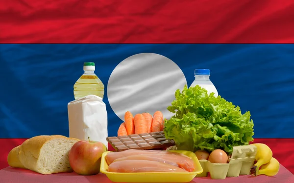 Basic food groceries in front of laos national flag