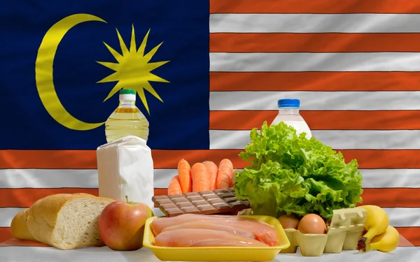 Basic food groceries in front of malaysia national flag