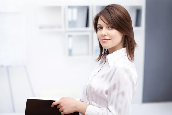 Portrait of beautiful young business woman holding folder at off
