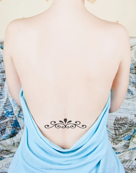 Naked back over white with tattoo