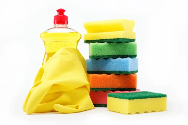 Detergent bottle, rubber gloves and cleaning sponge on a white b