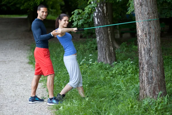 Personal trainer working with his client. Resistance band exerci