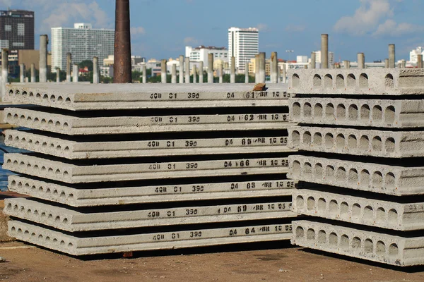 Pallets of new concrete blocks under sunlight against blue sky