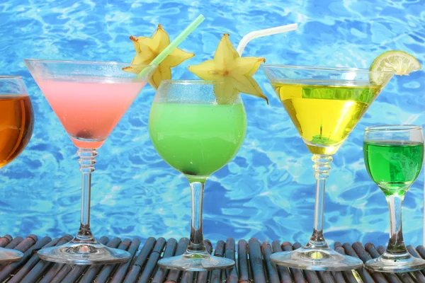 Stock Photo: Glasses of cocktails on table on blue sebackground