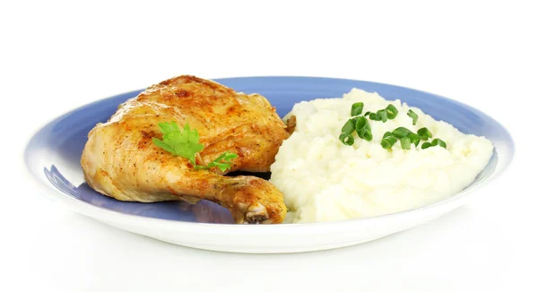 Roasted chicken leg with mashed potato in the plate isolated on white close-up