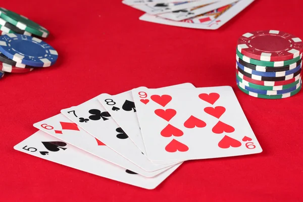 The red poker table with playing cards. The combination of straight
