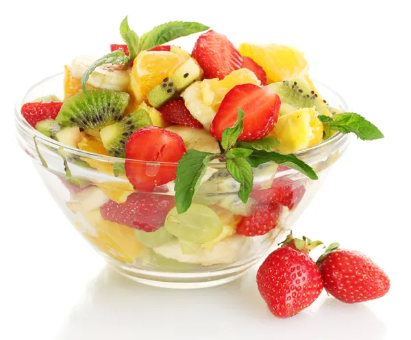 Glass bowl with fresh fruits salad and berries isolated on white
