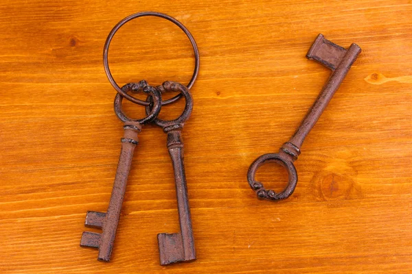 A bunch of antique keys on wooden background