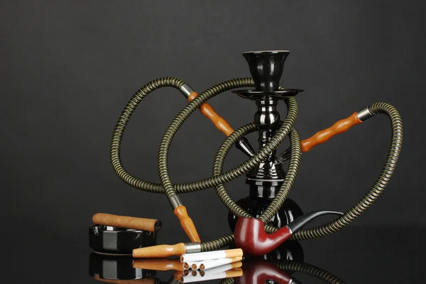 Smoking tools - a hookah, cigar, cigarette and pipe isolated on black background