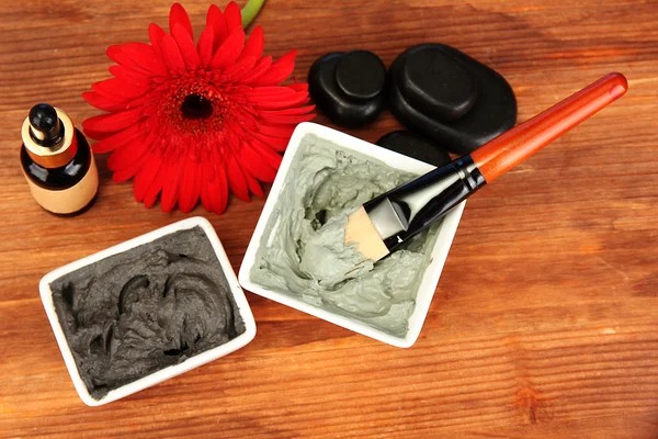 Cosmetic clay for spa treatments on wooden background close-up