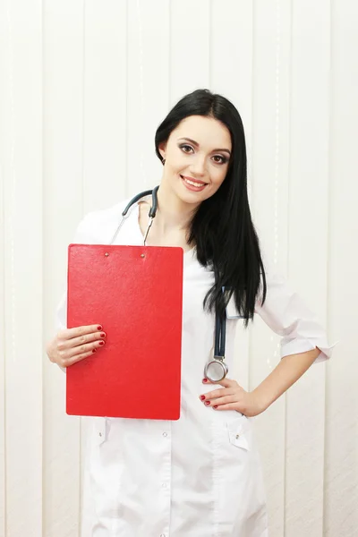 Young beautiful doctor handing folder