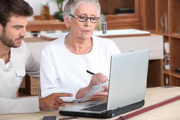 Man and senior woman in front of laptop computer