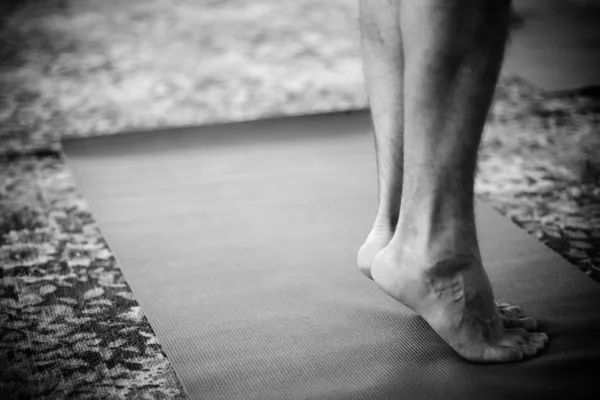 Feet standing on yoga mat