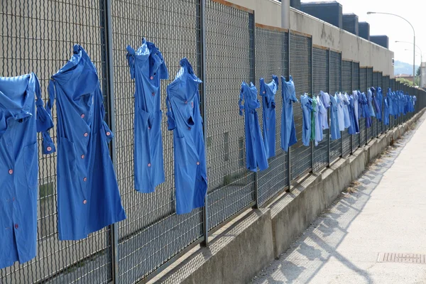 Blue shirts stretched out into the net during a strike of worker