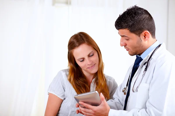 Attractive hispanic doctor conversing with a woman