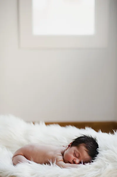 Sweet newborn on a white blanket dreaming — Stock Photo #11969513