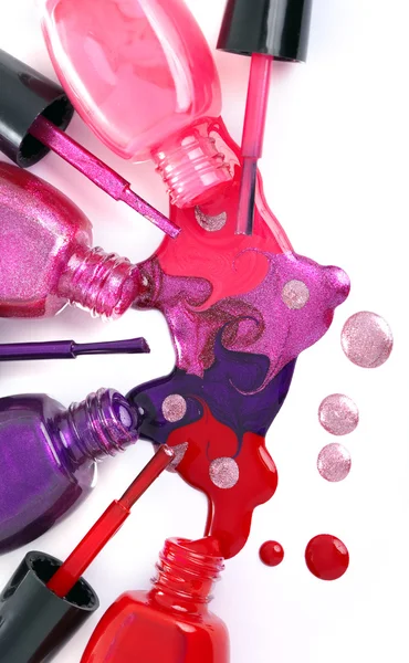 Ñolored nail polish spilling from bottles