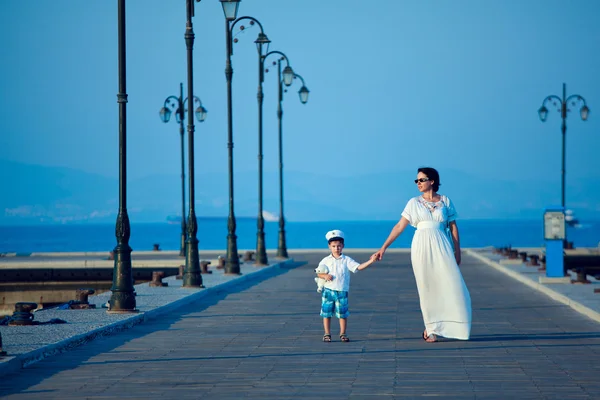 Happy woman and her little son on wooden jetty
