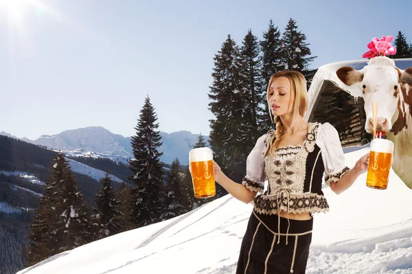 Sexy woman in snow and mountains serving beer