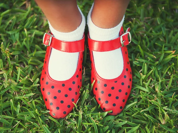 Red shoes with polka dots on a background of grass