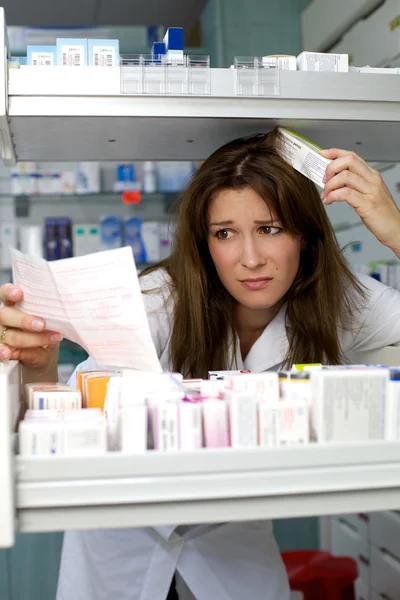 Pharmacist woman looking for medicine worried