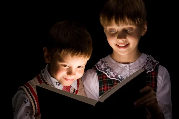 Image of smart children reading interesting book