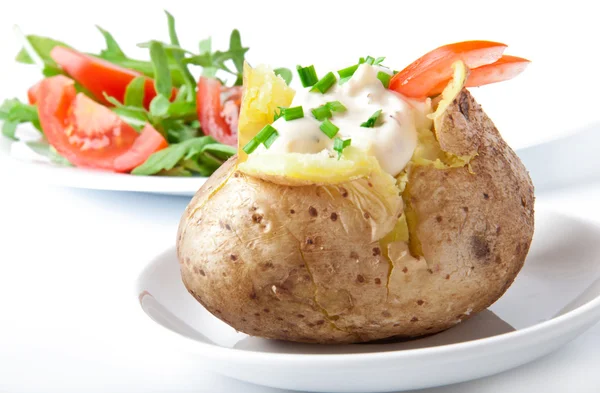 Baked potato filled with sour cream and arugula