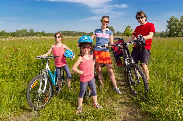 Happy family on bikes, cycling outdoors