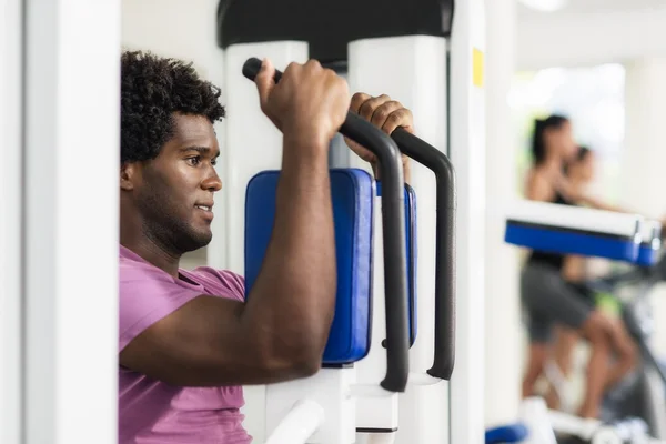 Young african american man training in fitness gym