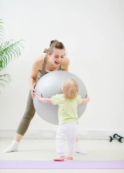 Mom and baby playing with fitness ball