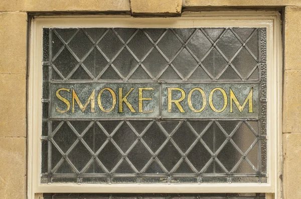 Old gold smoke room sign in an English pub window