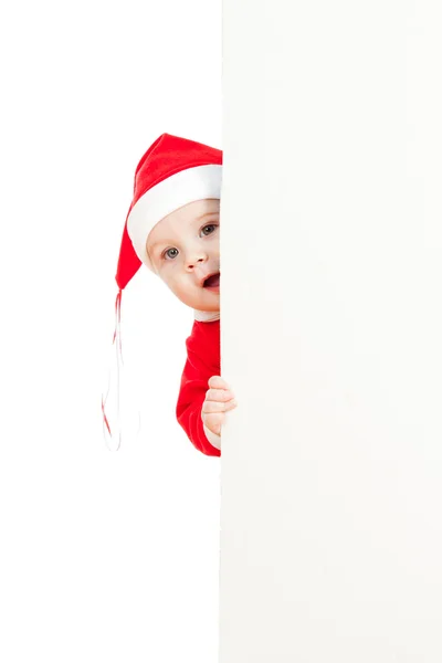 Small Santa claus child looking from behind the placard