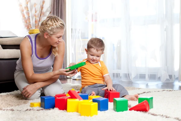 Cute mother and kid boy playing together indoor