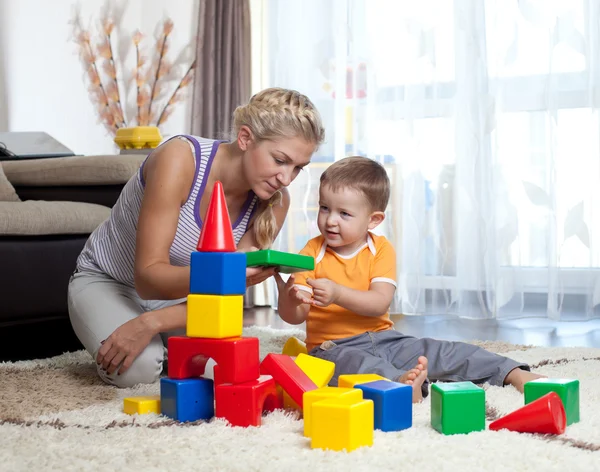 Cute mother and child boy playing together indoor