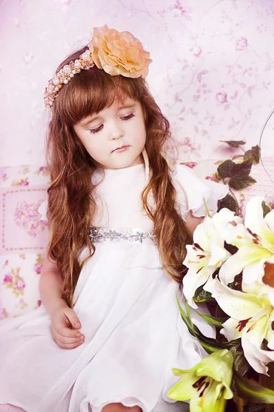 Portrait of a cute young girl wearing a flower headband in studio