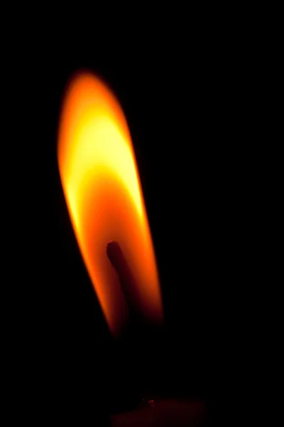 Closeup of burning candle isolated on black background — Stock Photo #11921391