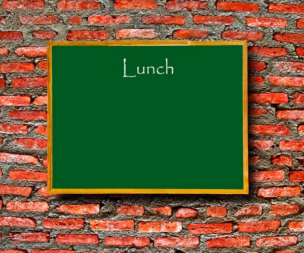 The Green menu blackboard with empty space on brick wall background