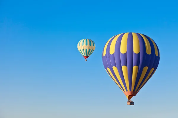 Hot air balloons drifting across a blue sky